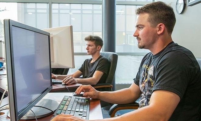 Two students working at computers in Finance Lab, Cybersecurity